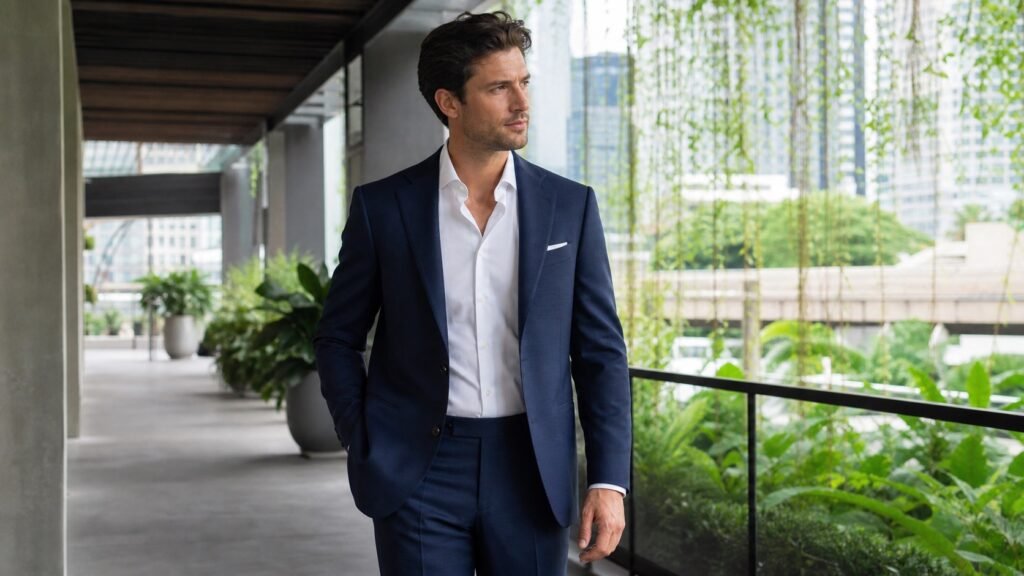 Fictional model wearing a lightweight navy tropical-wool suit in a shaded Bangkok setting.